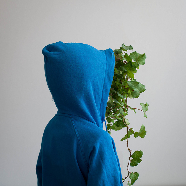 A blue hoodie where the face is a green plant
